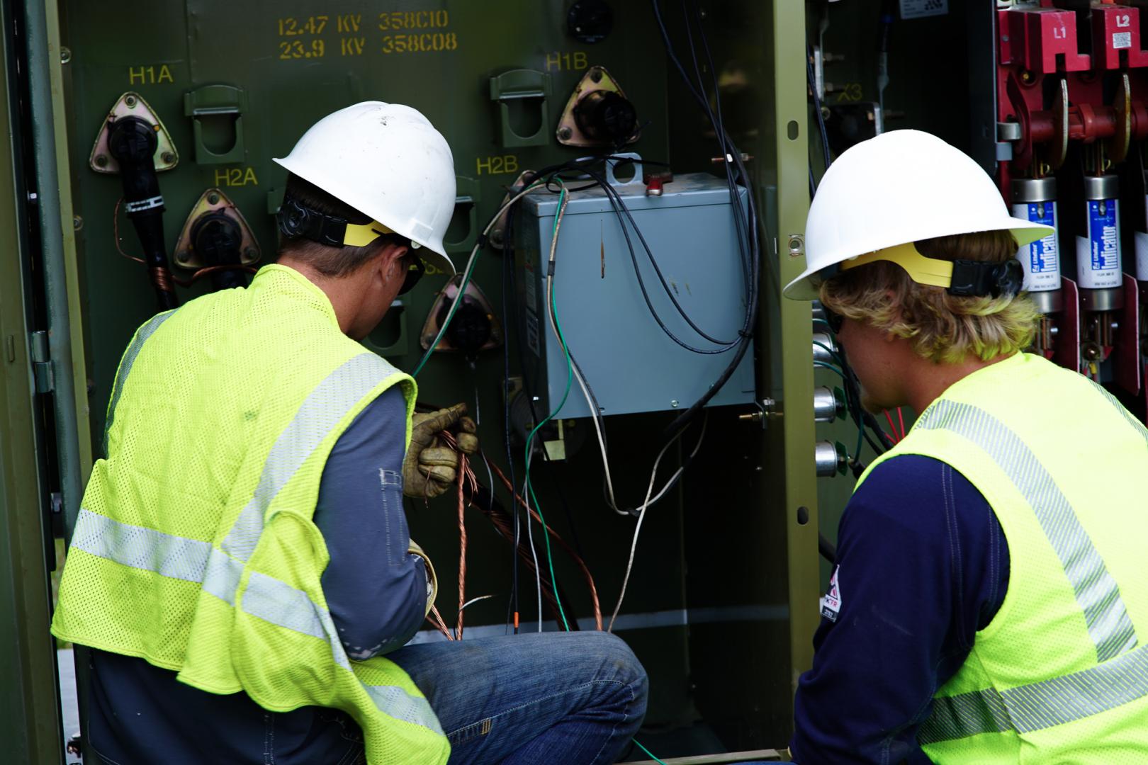 CCEC lineworkers in front of a transformer