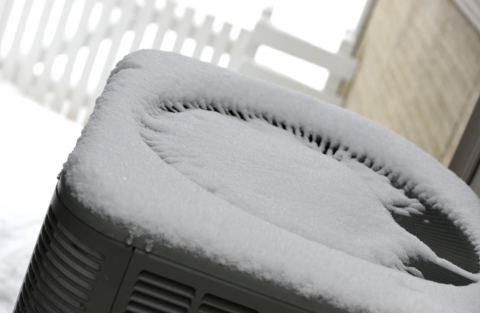 Air source heat pump with snow on top of it